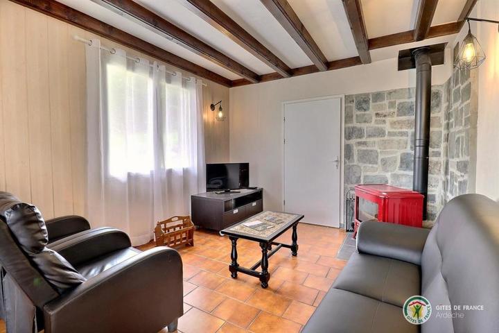 Coin salon avec canapé, fauteuils, table basse et TV