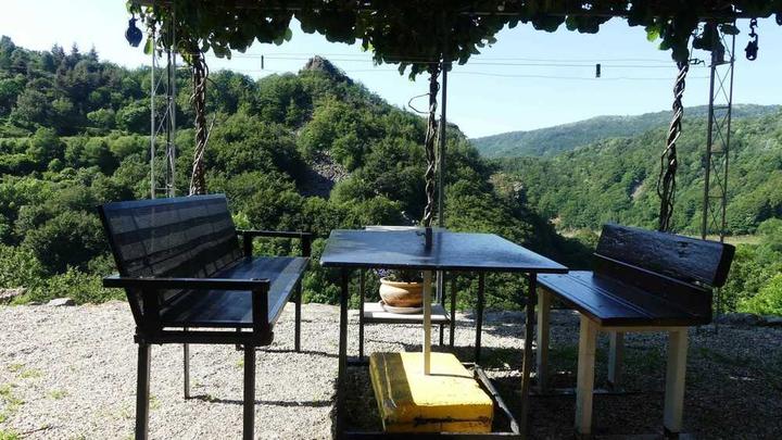 repas à l'extérieur sous pergolas, vue sur la nature.