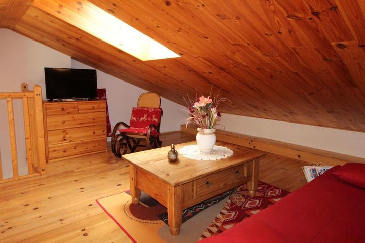 La mezzanine mansardée basse avec Tv écran plat, table basse.