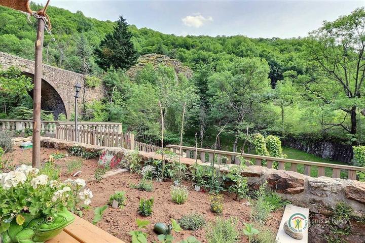 Vue sur le petit jardin et la rivière depuis la terrasse