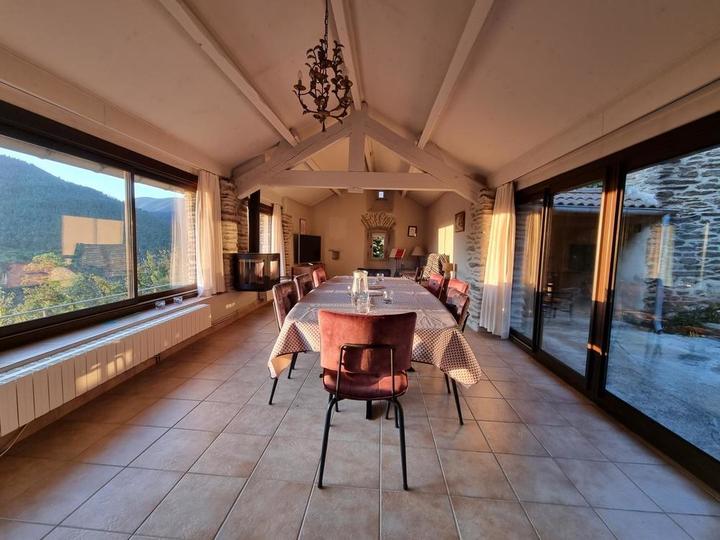 Le salon (vue de l'entrée de la pièce), avec le poêle pour les soirées d'hiver. Les baies vitrées permettent de profiter directement de la vue panoramique.